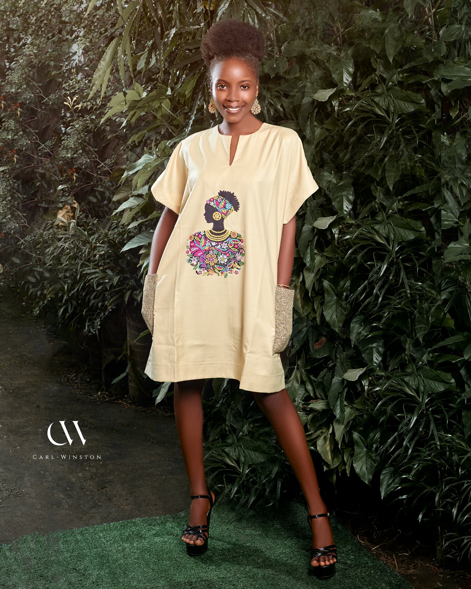 Carl-Winston beige African-inspired dress with a vibrant, colorful silhouette print, celebrating cultural heritage and elegance. Perfect for a stylish and comfortable look with deep pockets, adorned with matching accessories.
