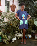 Carl-Winston navy blue African-inspired dress with an intricate print of a woman in traditional headwrap, complemented by light mint green pockets. This culturally rich and stylish dress brings elegance and comfort, ideal for those looking to celebrate heritage with modern flair.