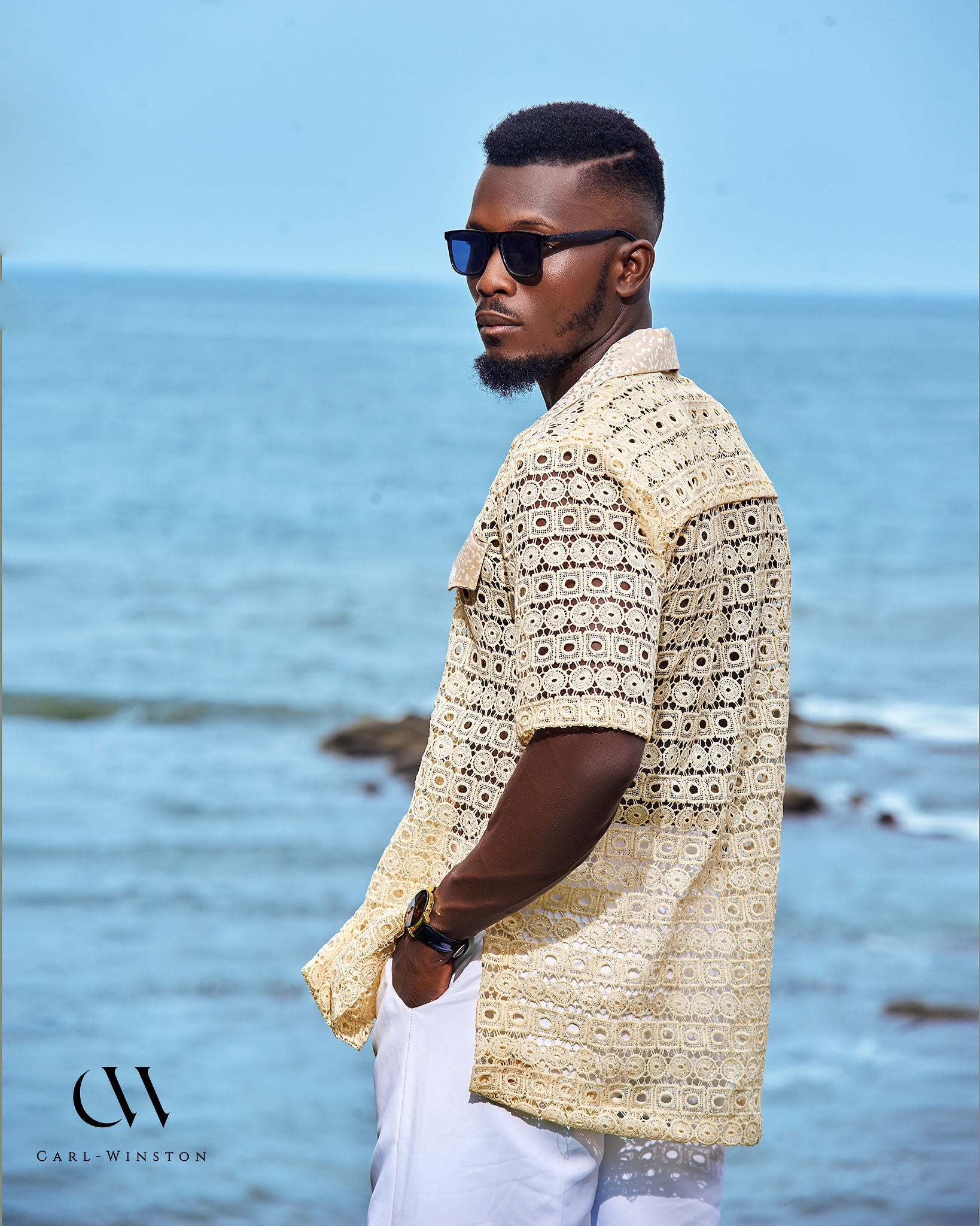 Side profile of man wearing Carl-Winston’s Coastal Breeze Crochet Shirt near the beach.