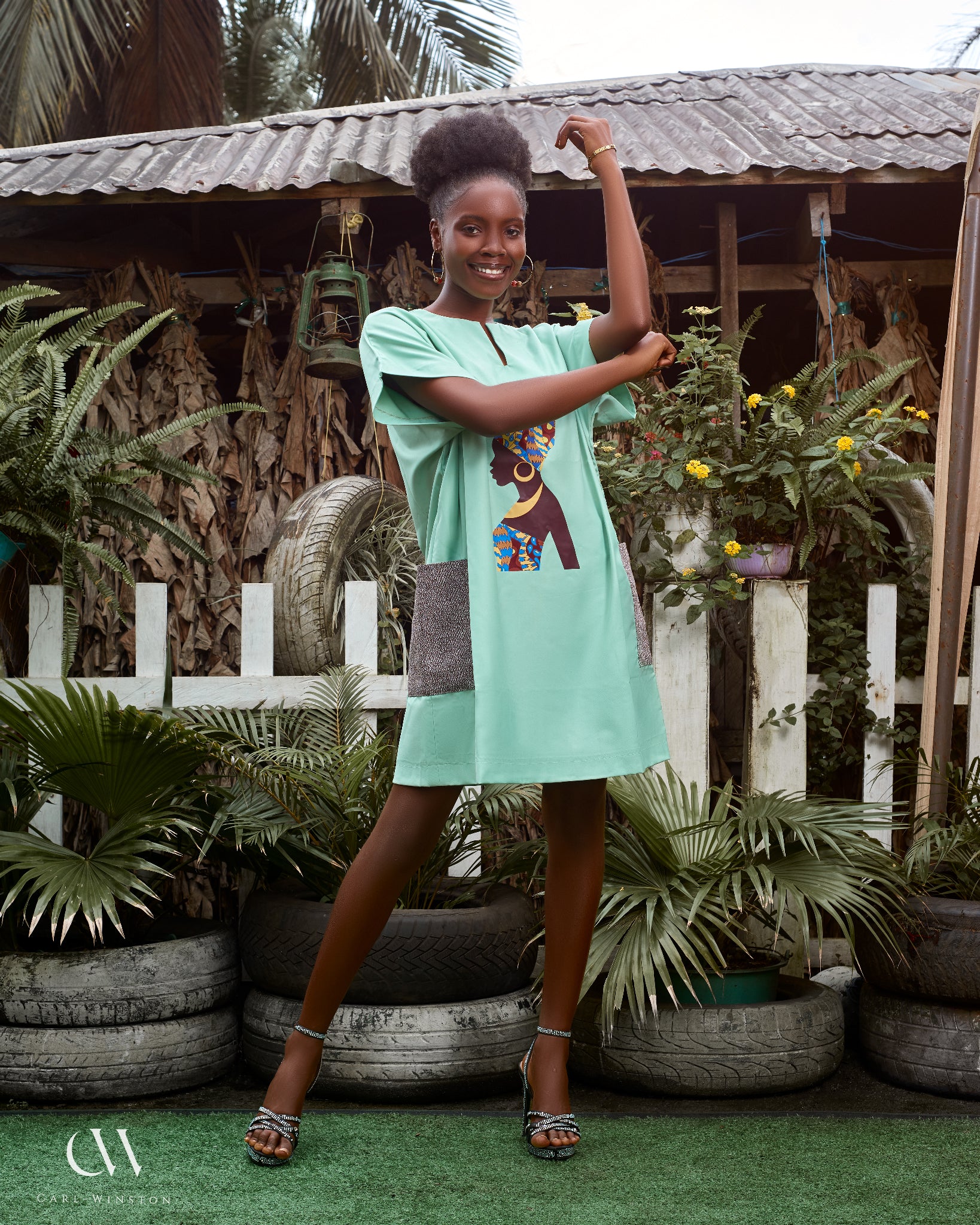 Carl-Winston mint green African dress featuring a silhouette print of a woman adorned in a vibrant, colorful headwrap and necklace. This stylish dress combines cultural elegance with modern simplicity, perfect for those seeking unique, heritage-inspired fashion.