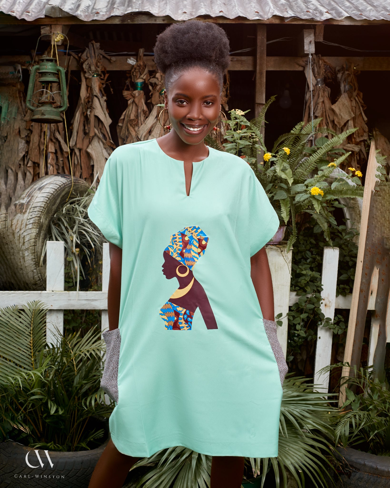 Carl-Winston mint green African dress featuring a silhouette print of a woman adorned in a vibrant, colorful headwrap and necklace. This stylish dress combines cultural elegance with modern simplicity, perfect for those seeking unique, heritage-inspired fashion.