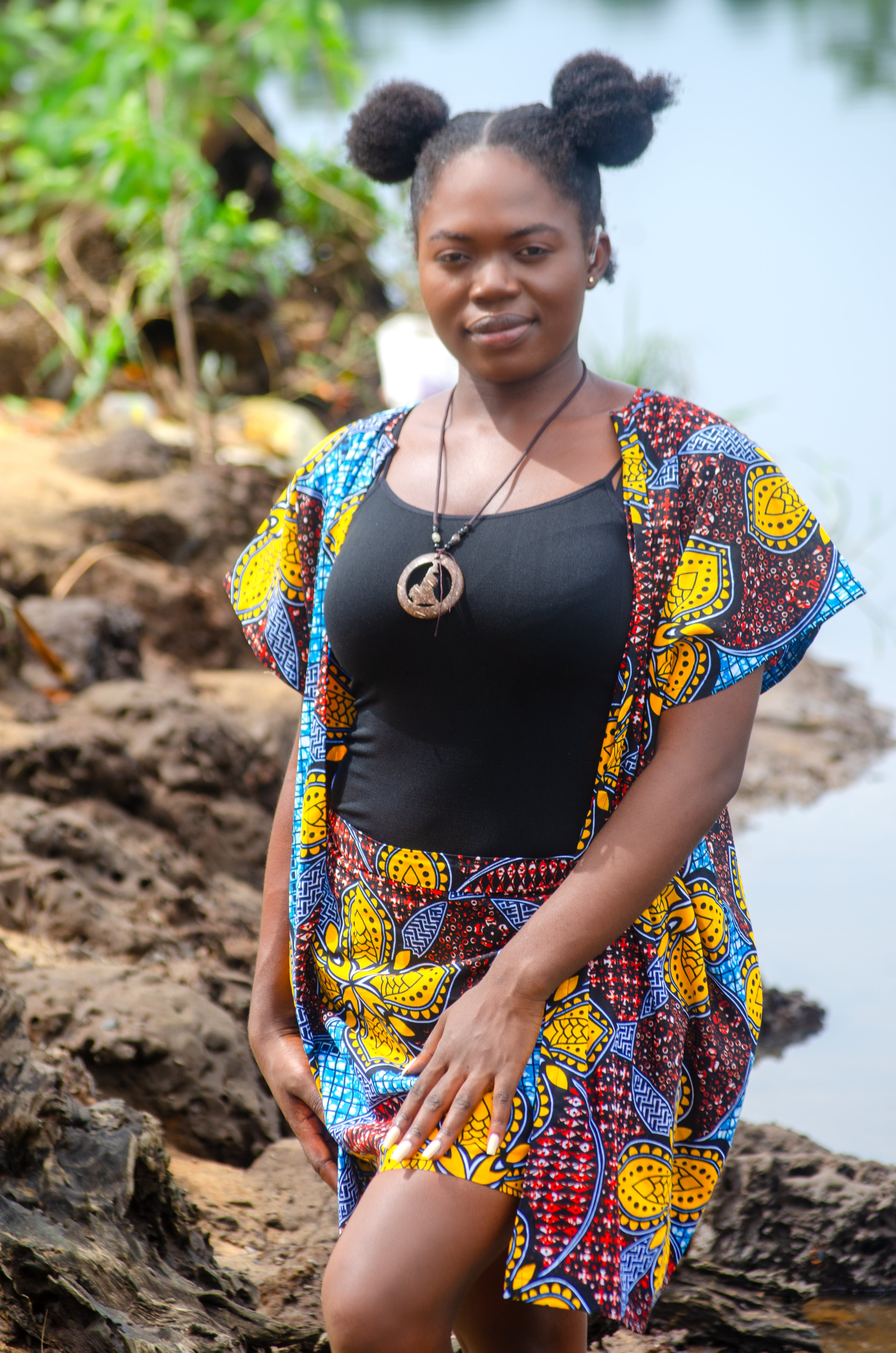 African woman vibrant yellow blue patterned Carl-Winston kimono set over a black top