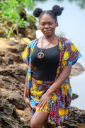 African woman vibrant yellow blue patterned Carl-Winston kimono set over a black top