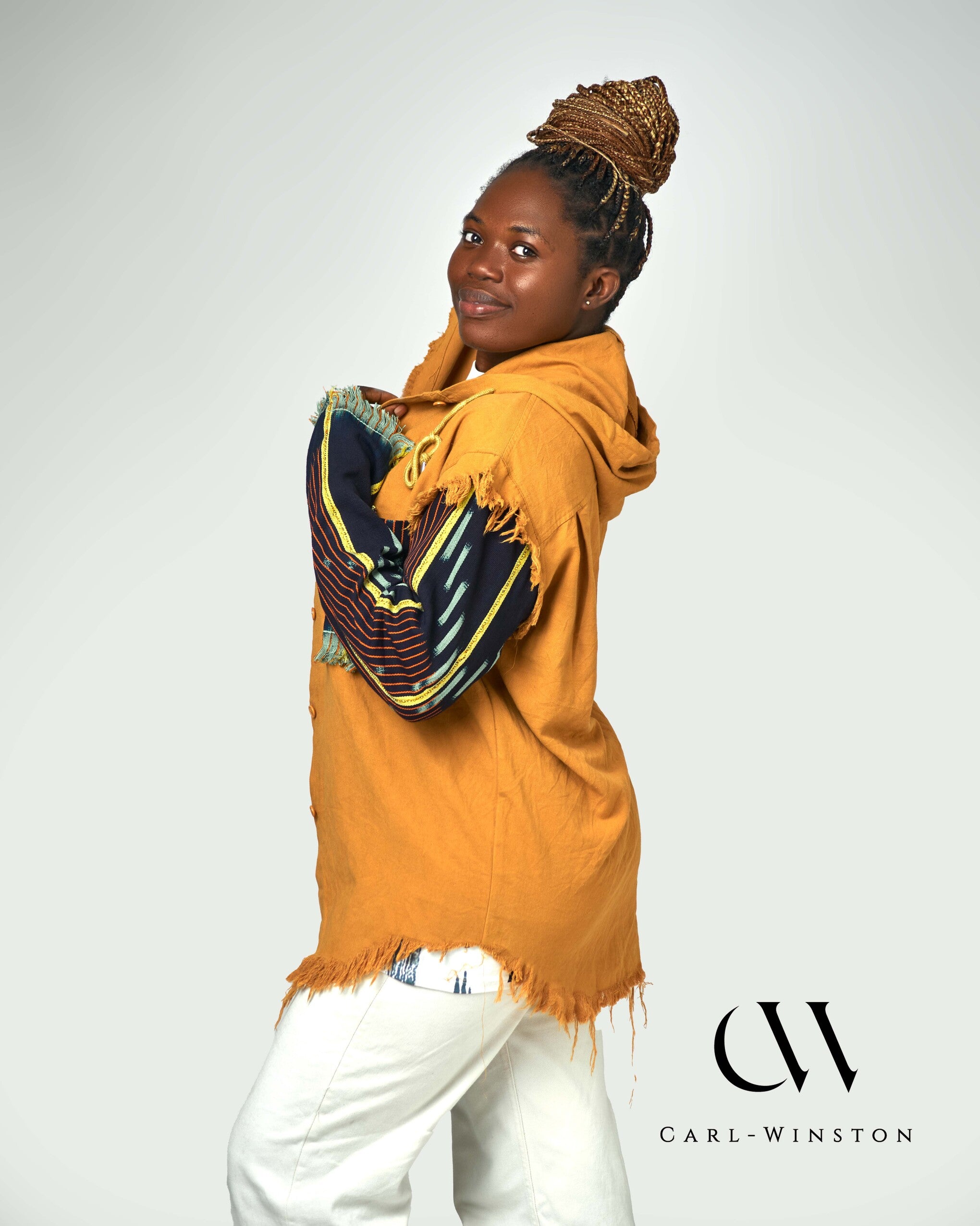 A confident woman models the Heritage Threads Hooded Jacket, pairing it effortlessly with neutral tones for a stylish and cultural aesthetic.