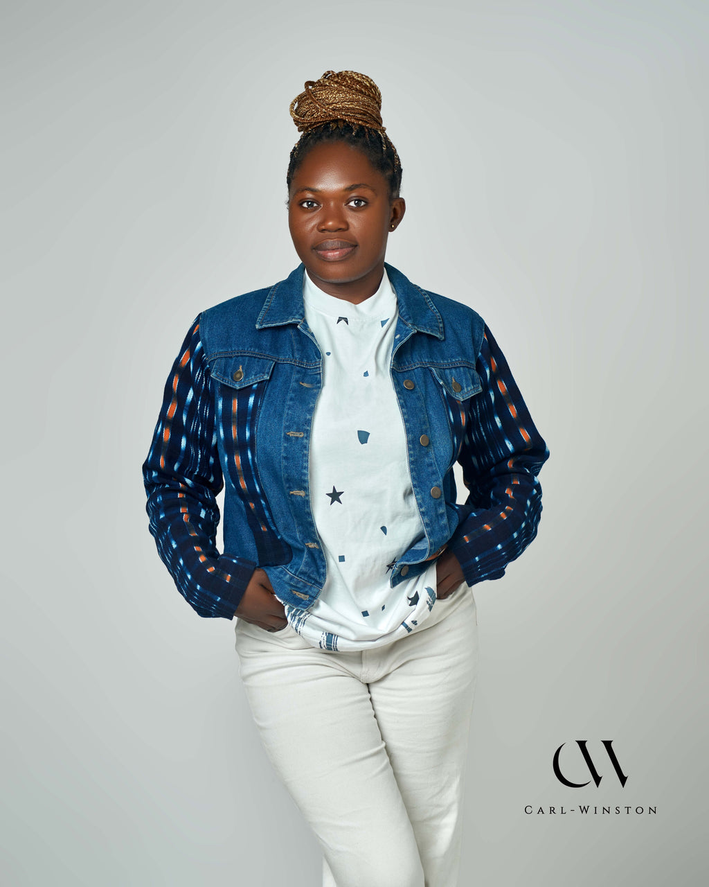 A stylish denim jacket with bold Kente cloth accents on the sleeves, blending contemporary fashion with traditional African heritage. Designed by Carl-Winston, this unique piece features deep indigo and orange hues, symbolizing wisdom and prosperity. Perfect for casual and smart-casual styling