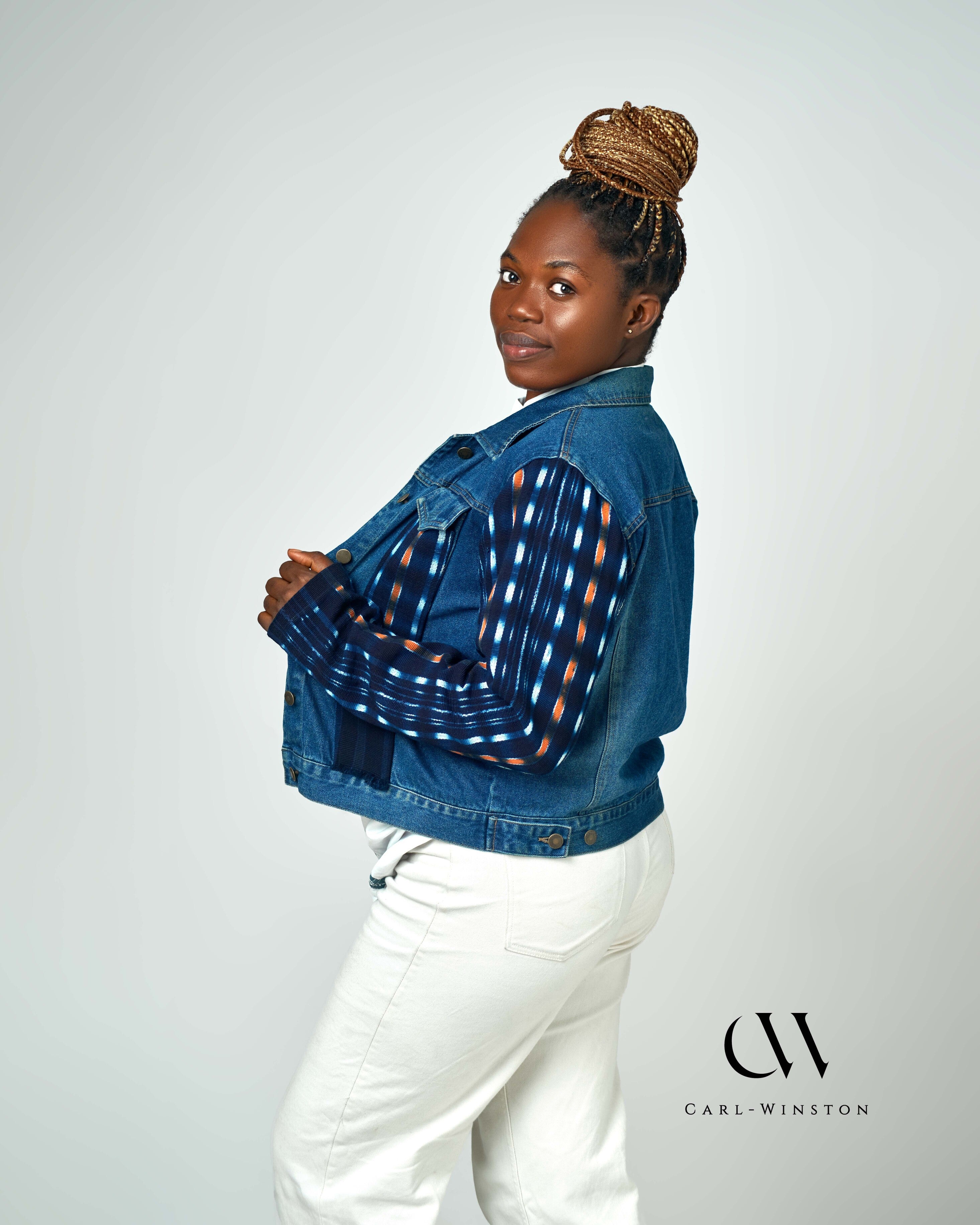 A stylish denim jacket with bold Kente cloth accents on the sleeves, blending contemporary fashion with traditional African heritage. Designed by Carl-Winston, this unique piece features deep indigo and orange hues, symbolizing wisdom and prosperity. Perfect for casual and smart-casual styling