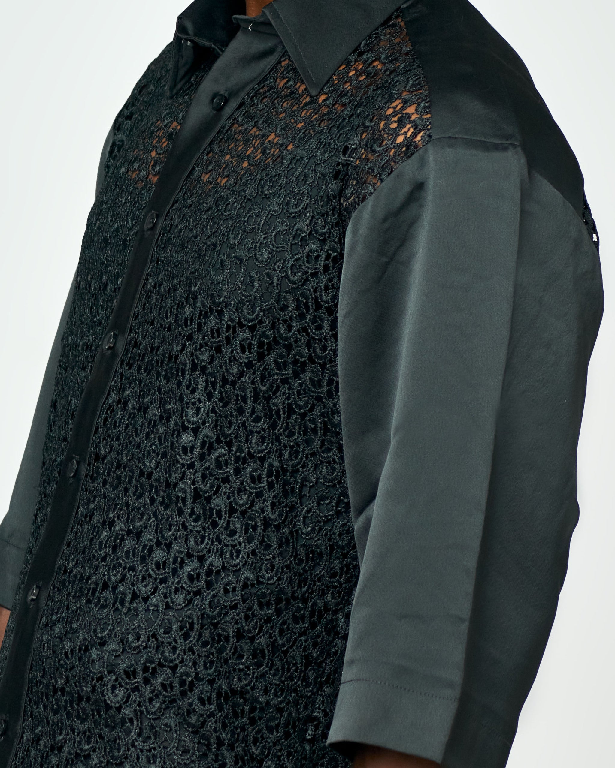 Close-up of intricate black lace detailing on a premium men’s button-up shirt, combining elegance with masculine sophistication.