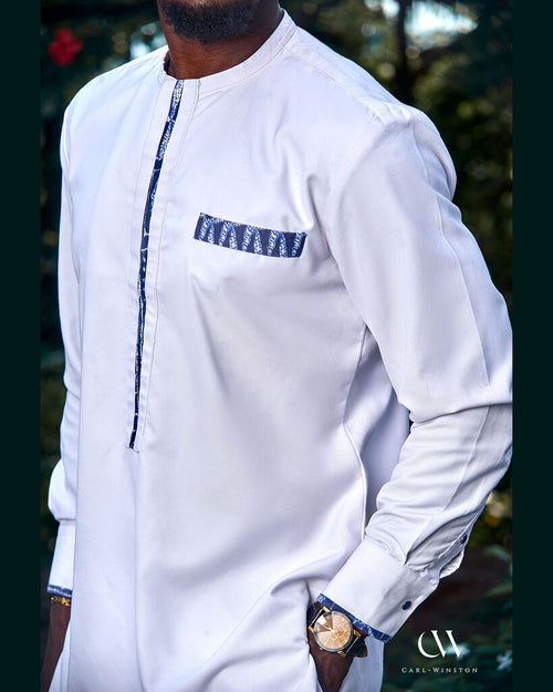 Close-up of the Bamileke Ceremony Kaftan showcasing detailed Bamileke fabric along the collar, chest pocket, and sleeve cuffs on crisp white cotton.