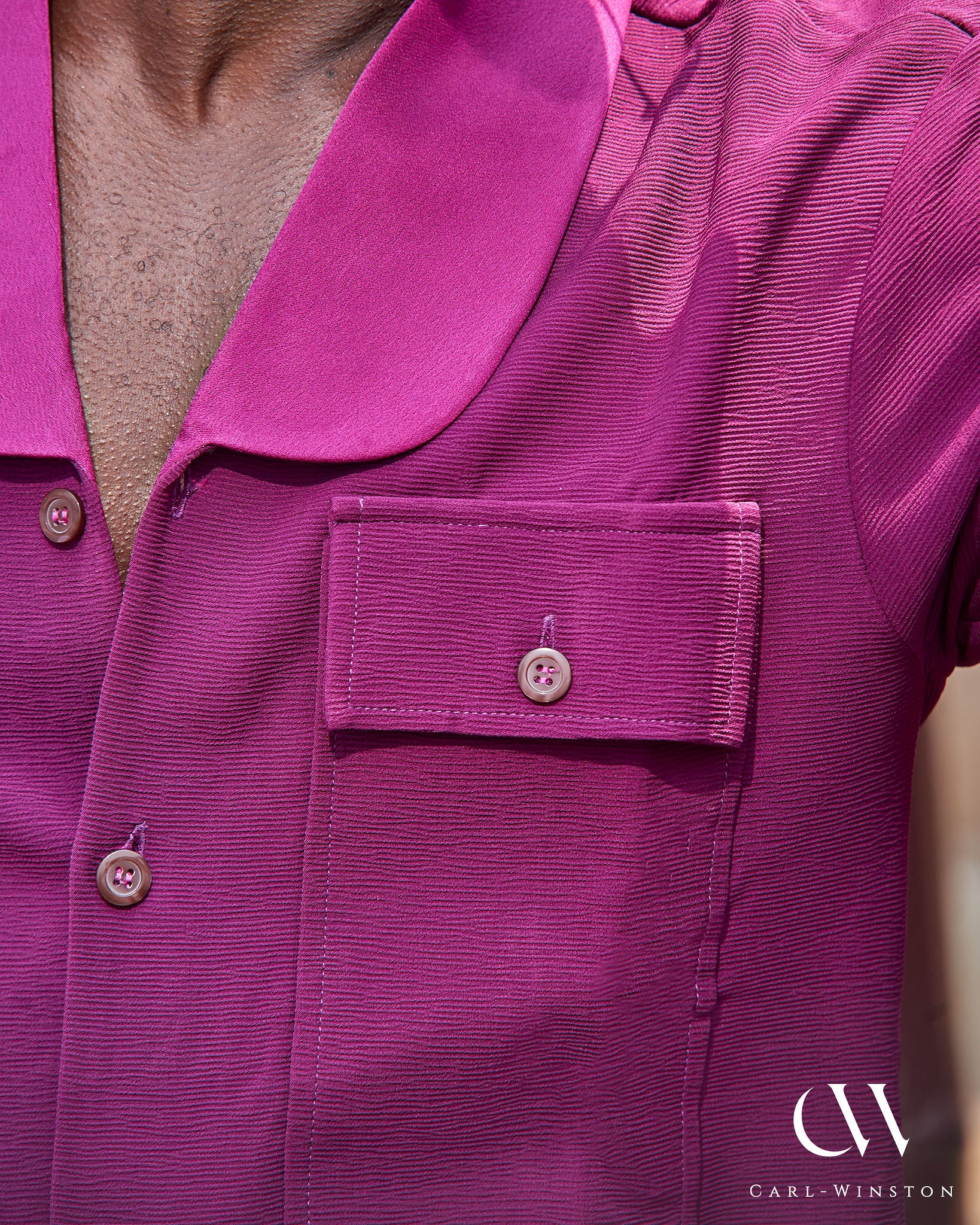 Close-up of wine-colored short sleeve shirt with tonal buttons and chest pocket detail.